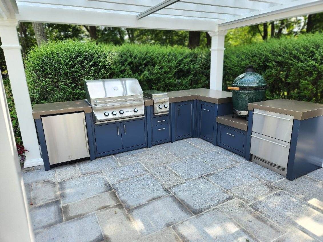 A large outdoor kitchen with a grill and a green egg.
