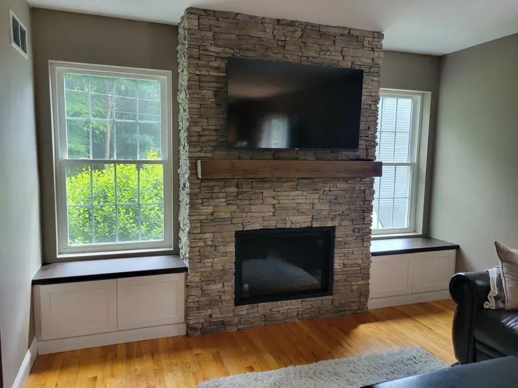 A living room with a fireplace and a flat screen tv.