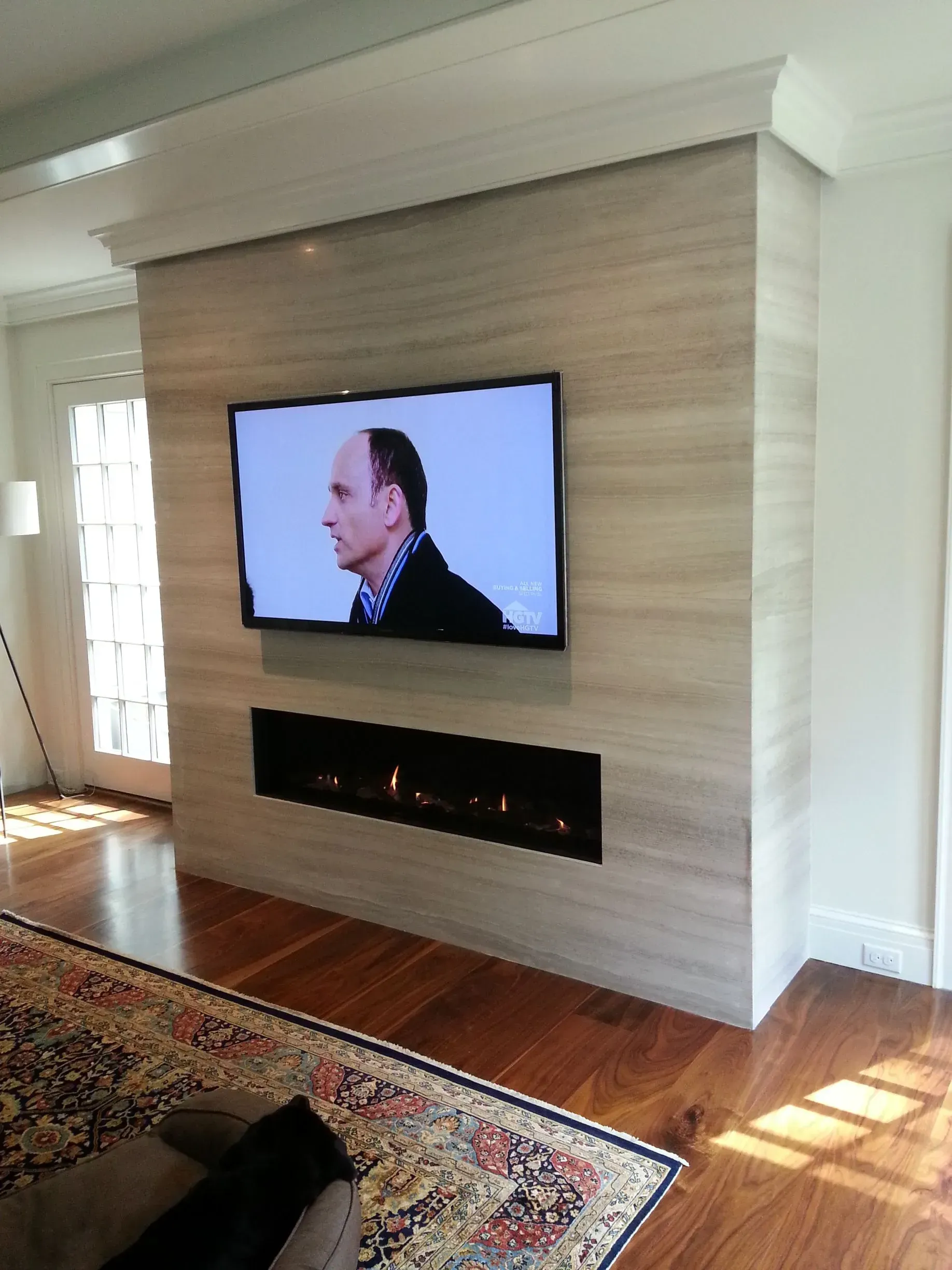 A living room with a fireplace and a flat screen tv on the wall