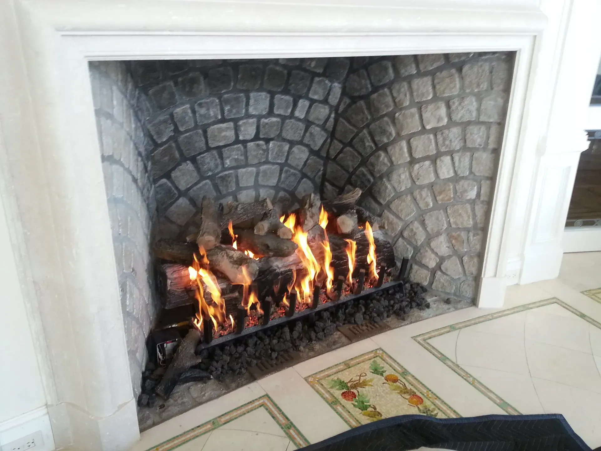 A wood fireplace with fire.