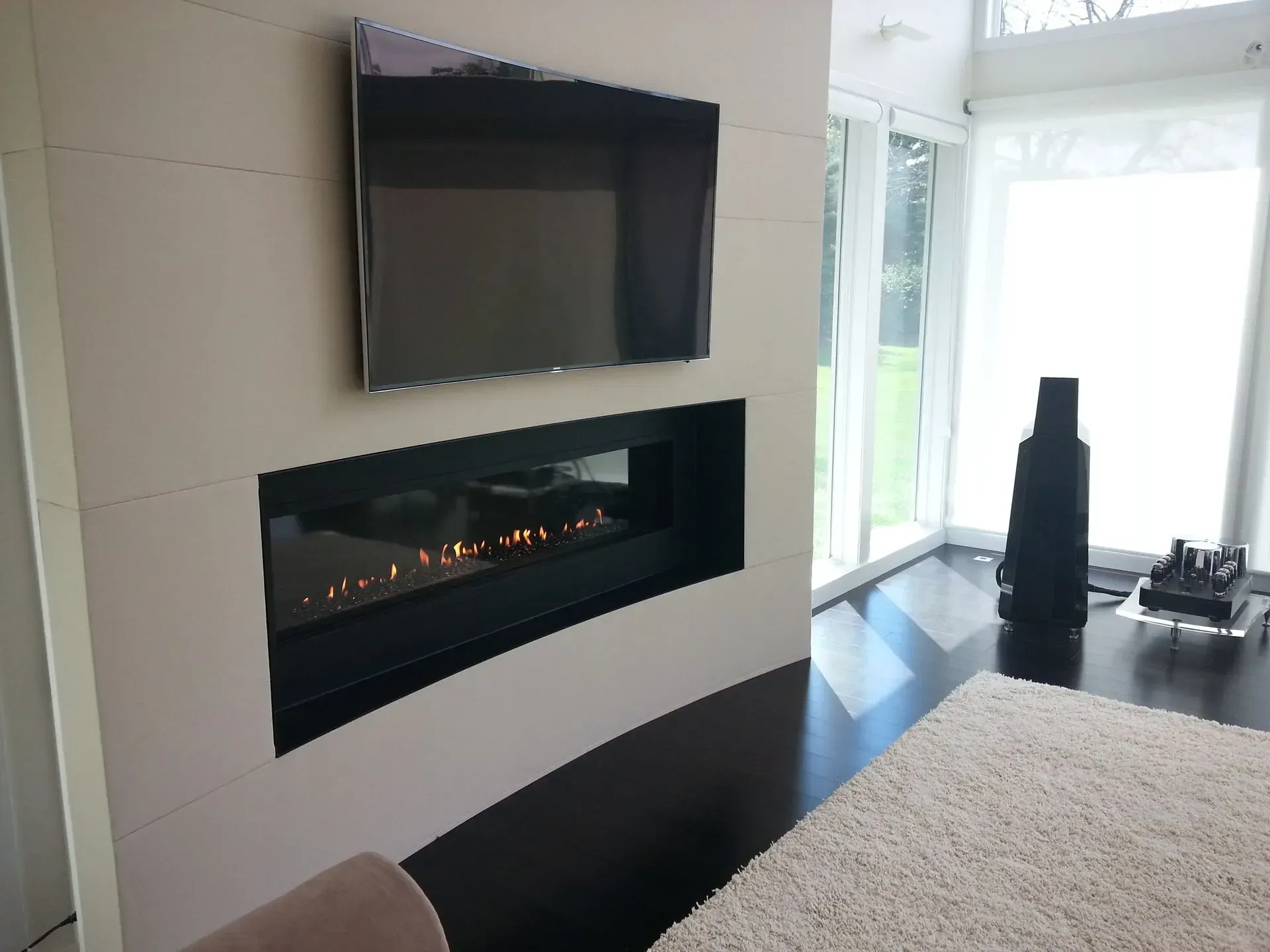 A living room with a fireplace and a flat screen tv
