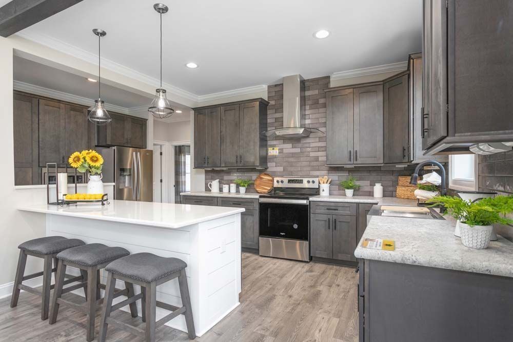 Modern kitchen with gray cabinets, white countertops, and stainless steel appliances.