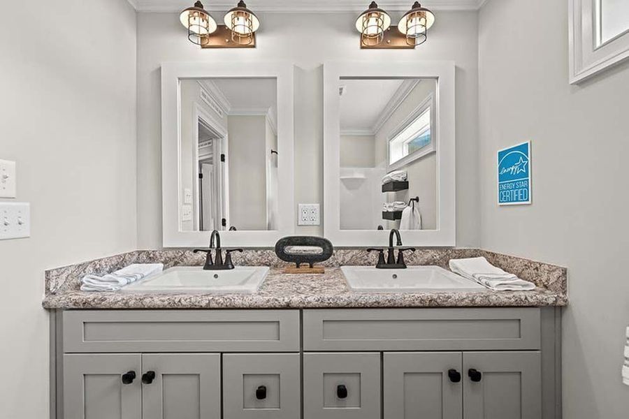 Double bathroom vanity with gray cabinets, two mirrors, and light fixtures.