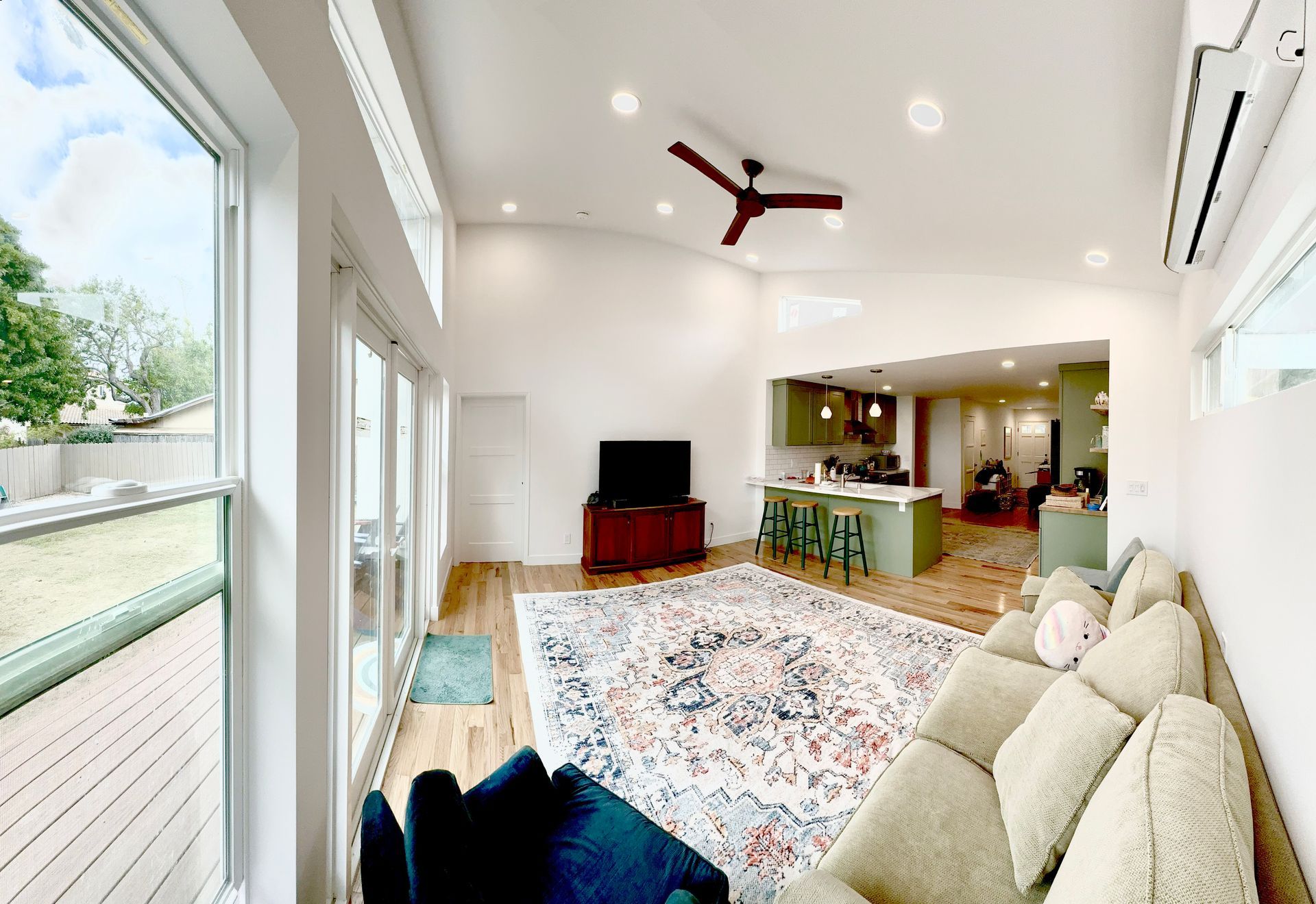 Bright living room with open layout, large windows, and a sectional sofa.