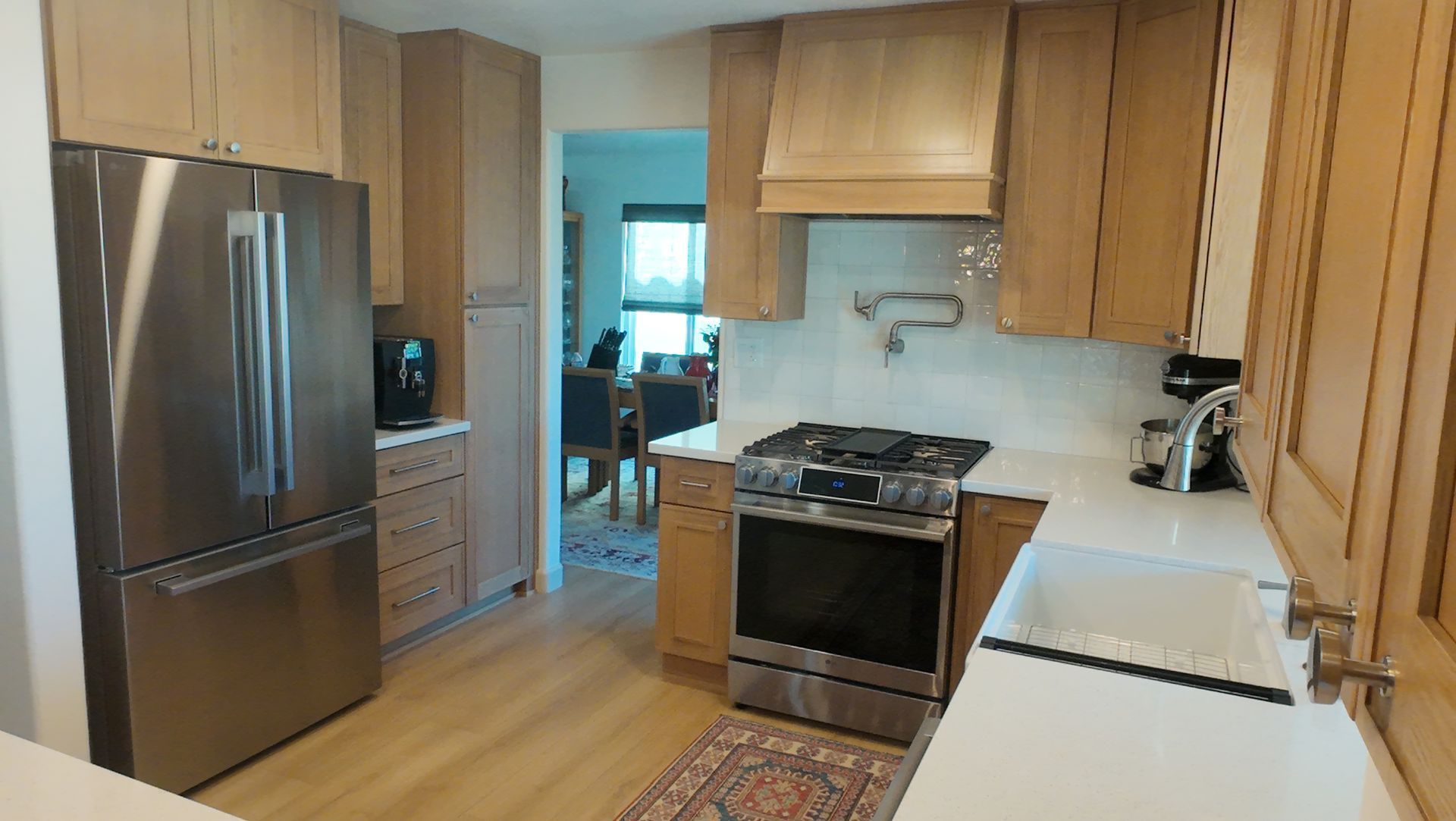 Kitchen with stainless steel appliances, light wood cabinets, and white countertops.