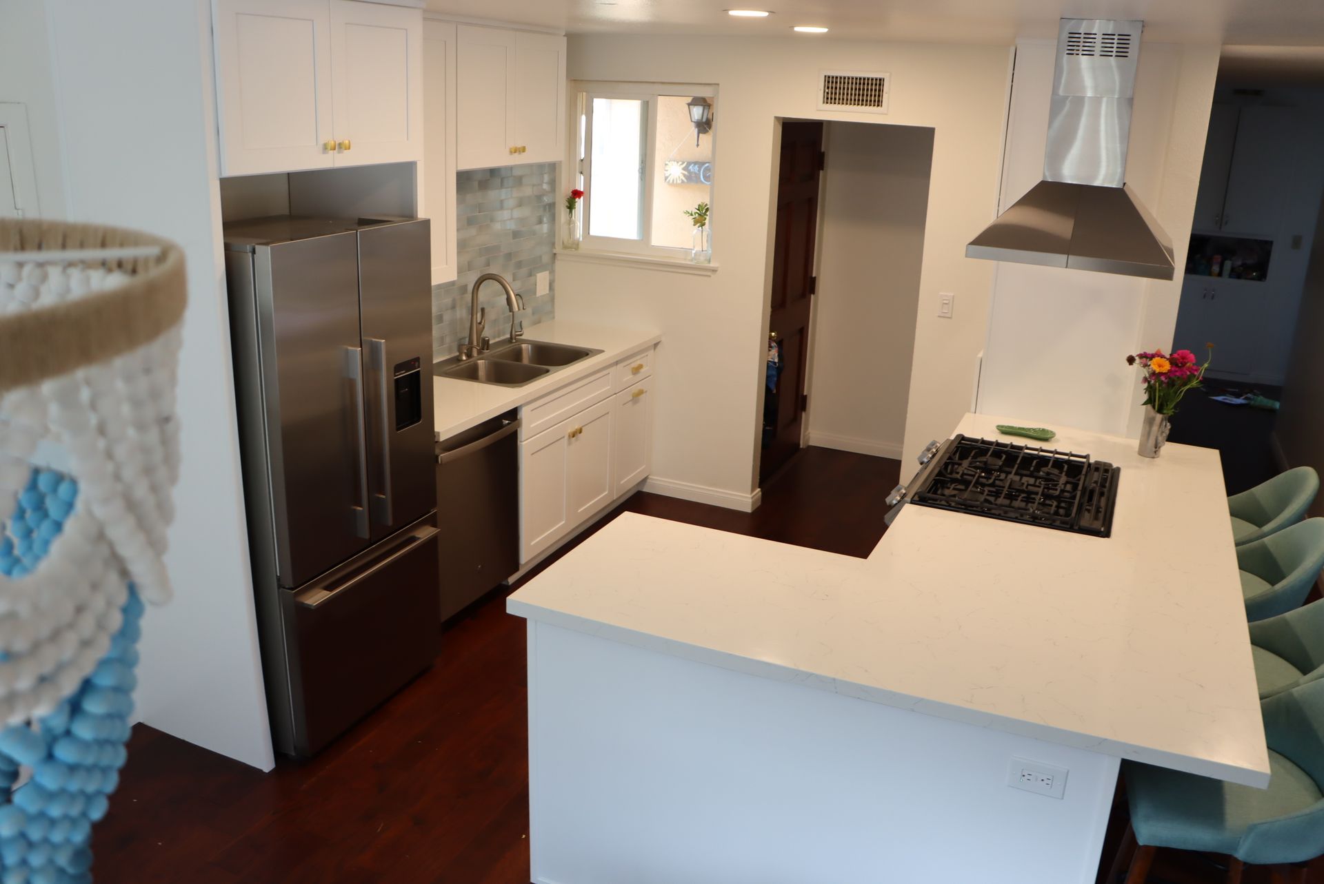 Modern kitchen with white cabinets, stainless steel appliances, and a countertop island.