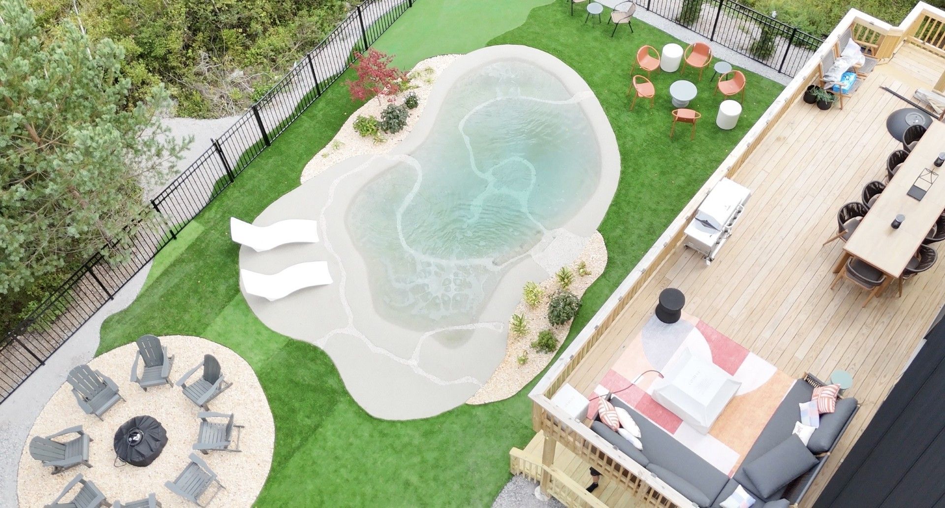 Aerial view of a backyard with a pool, seating areas, and a deck.