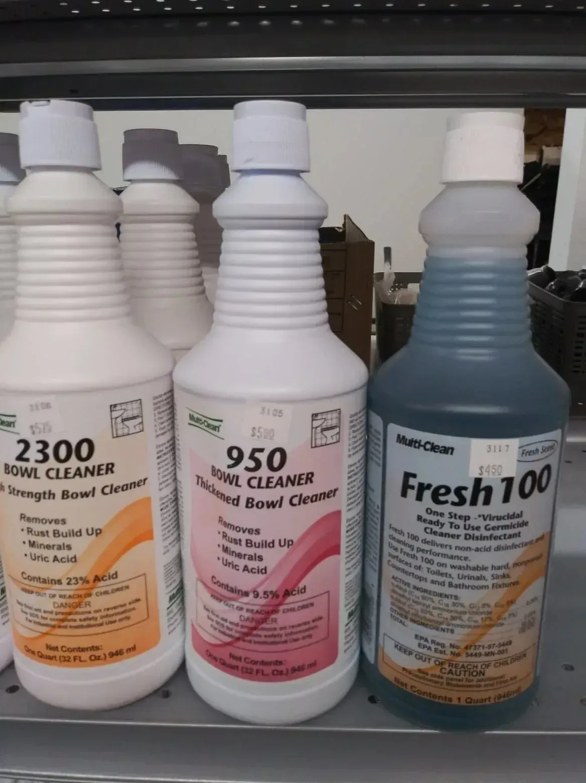 Three bottles of Multi-Clean brand toilet bowl cleaners—labeled 2300, 950, and Fresh 100—sit on a shelf.