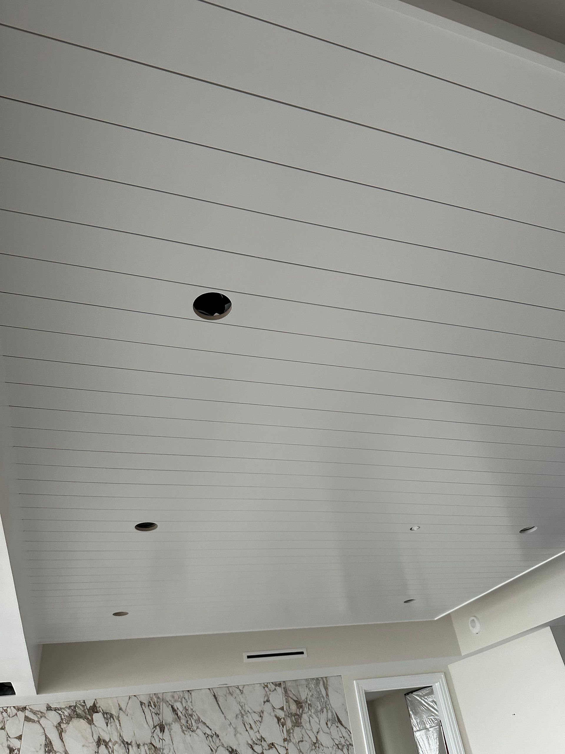 A white ceiling with holes in it in a room.