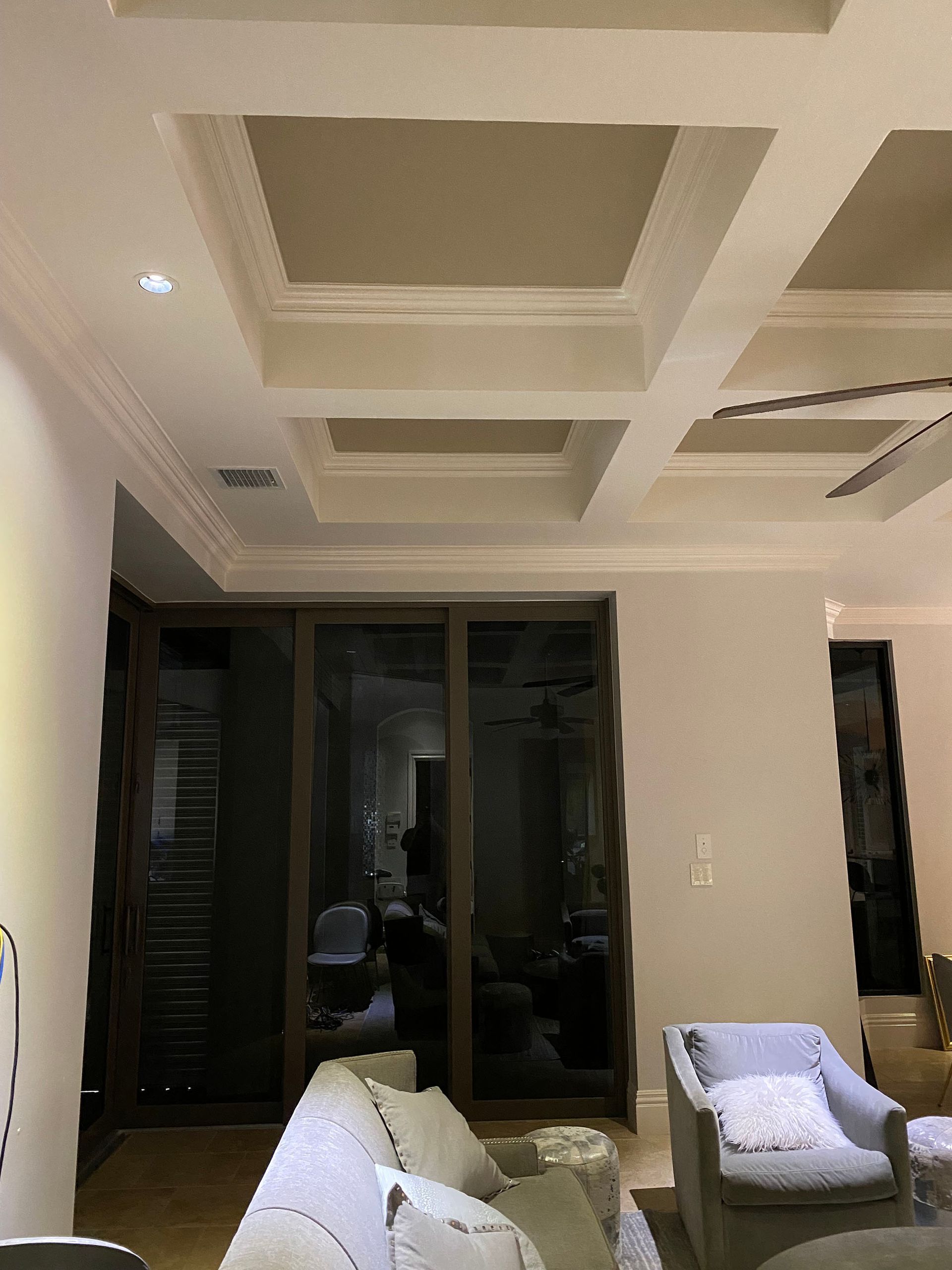 A living room with a couch , chair , table and sliding glass doors.