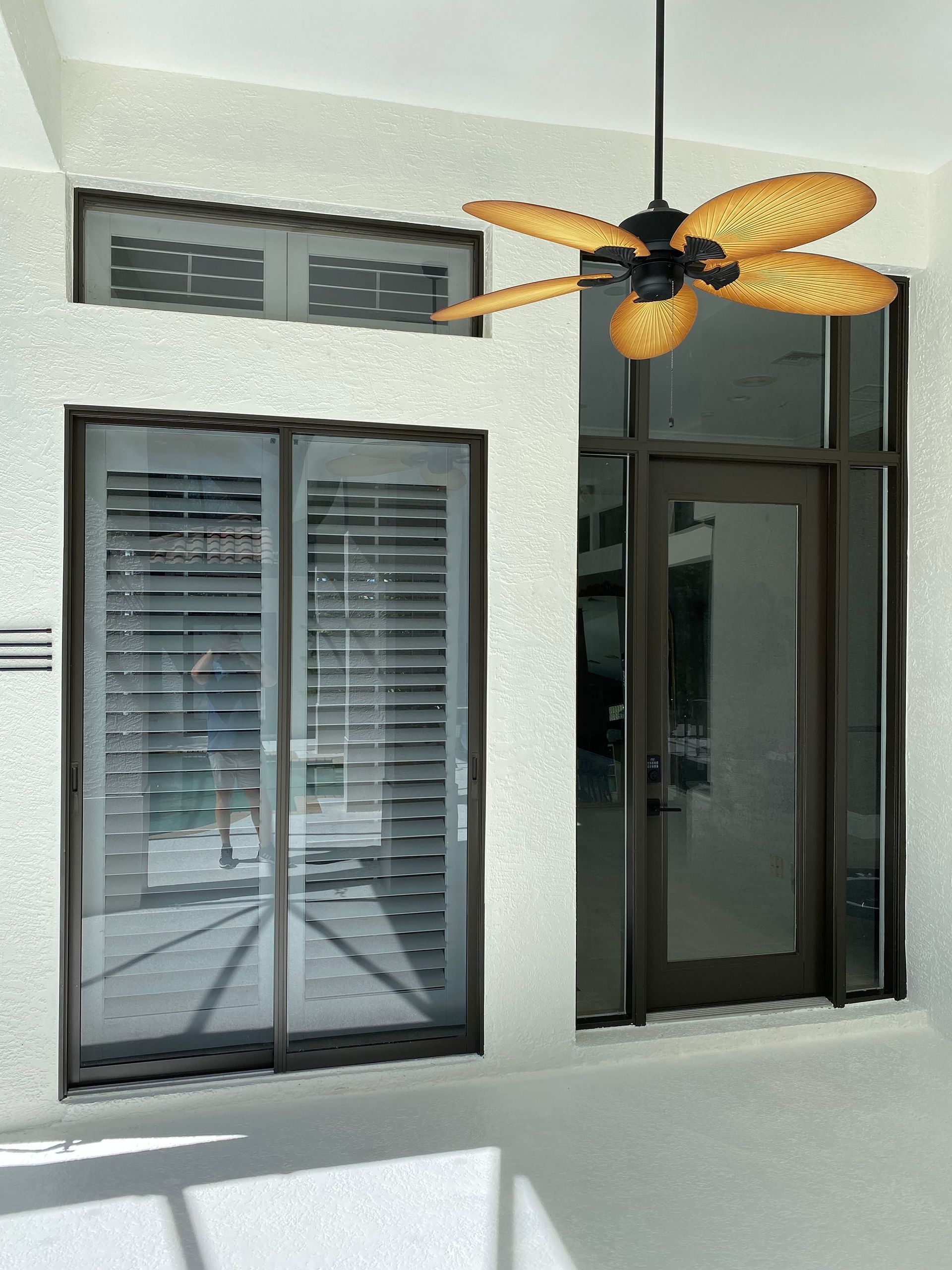 A ceiling fan is hanging from the ceiling above a sliding glass door