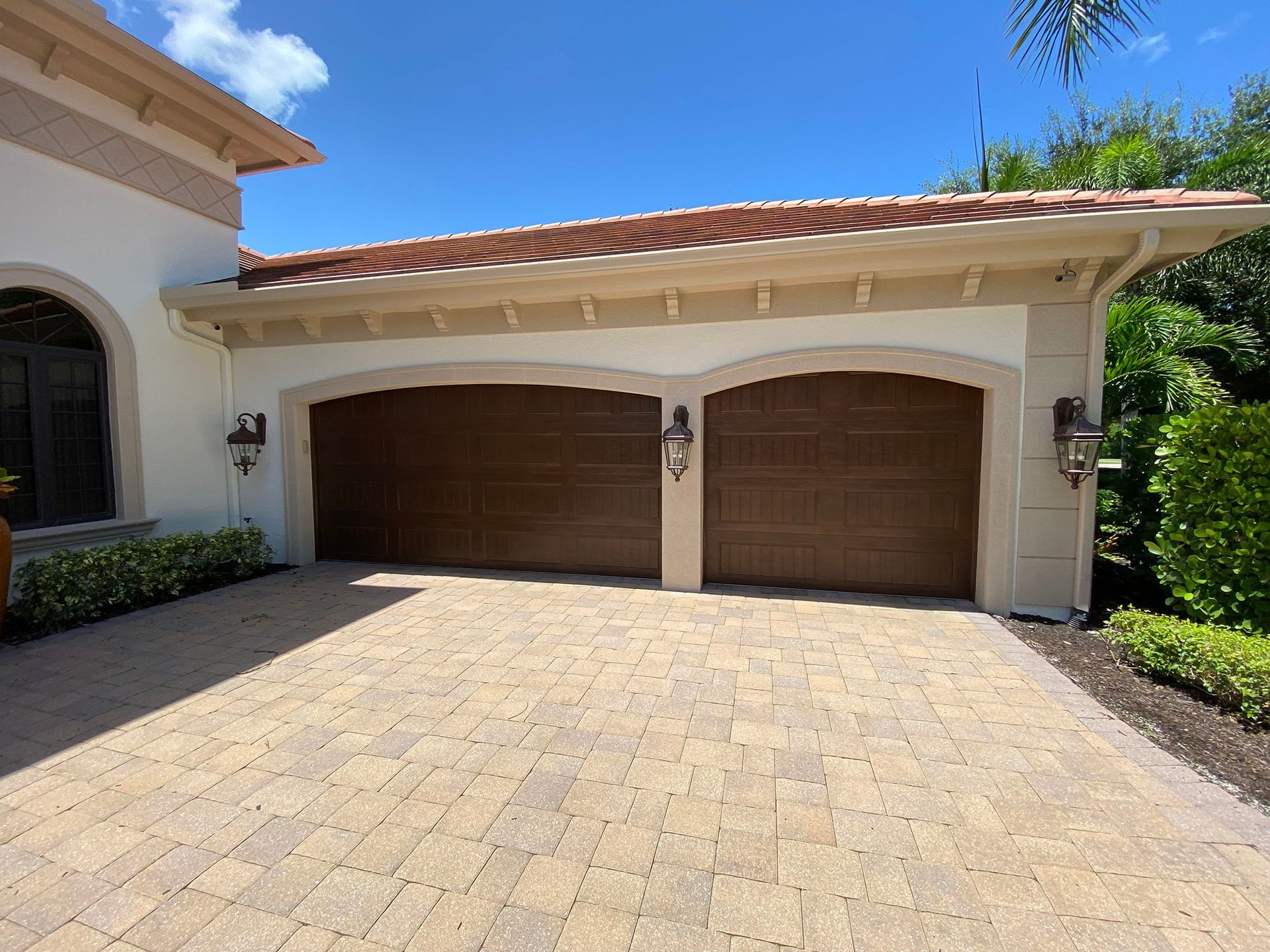 A house with two garage doors and a brick driveway