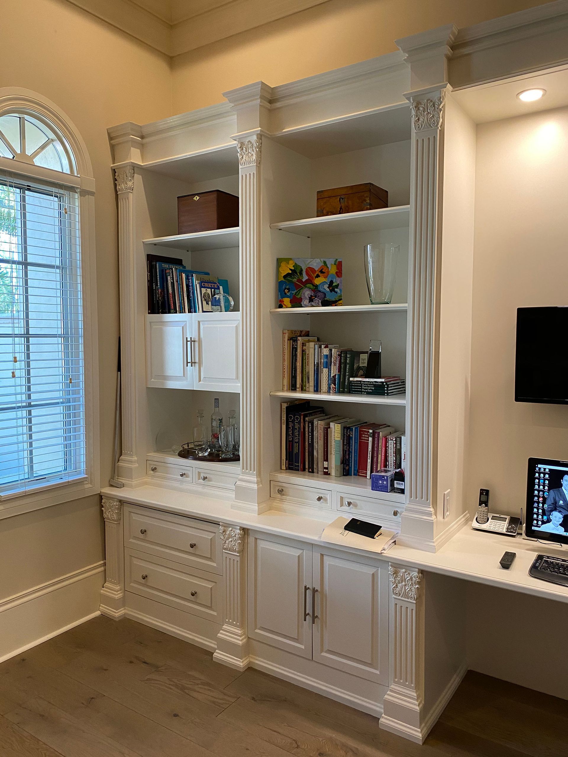 A room with a lot of shelves and a desk with a computer on it.