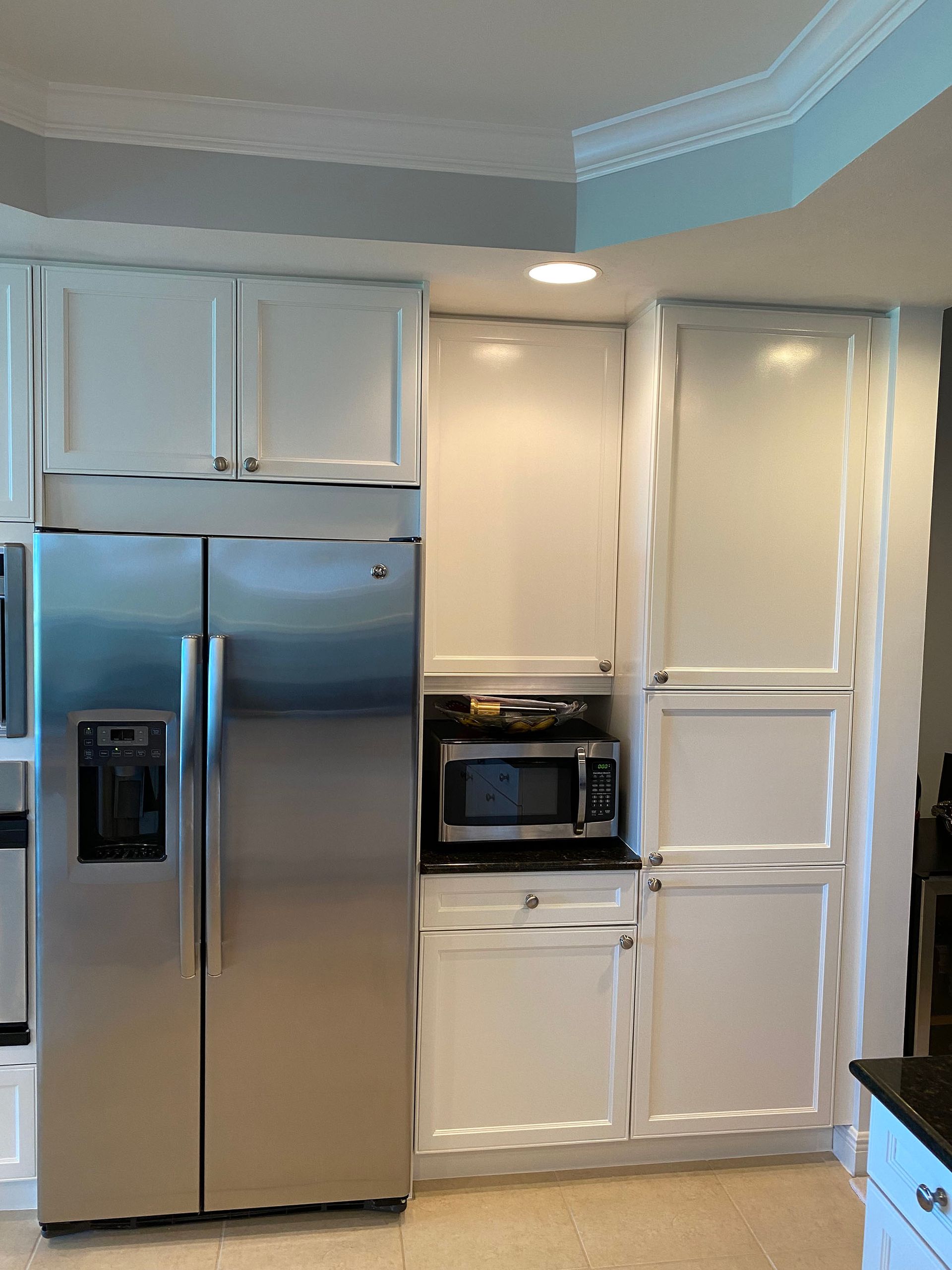 A kitchen with stainless steel appliances and white cabinets
