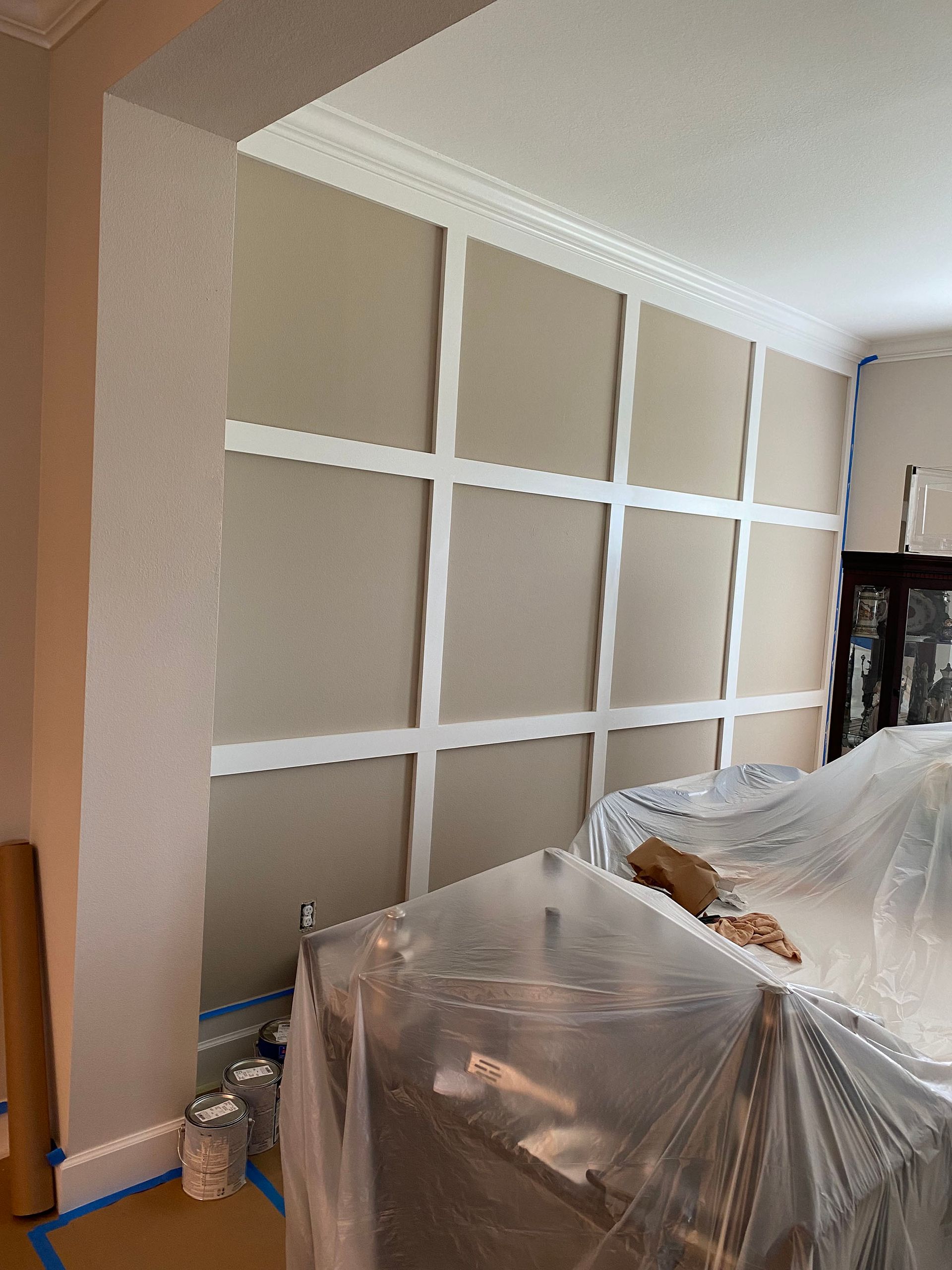 A living room with a couch and a table covered in plastic.