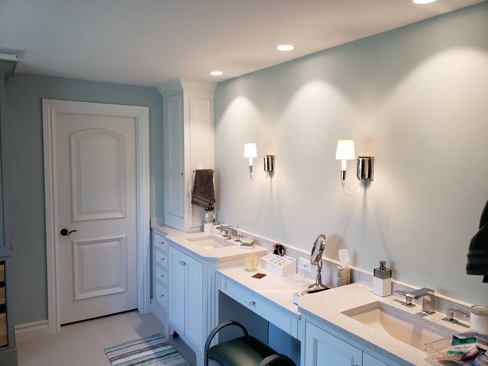 A bathroom with two sinks and two lights on the wall.