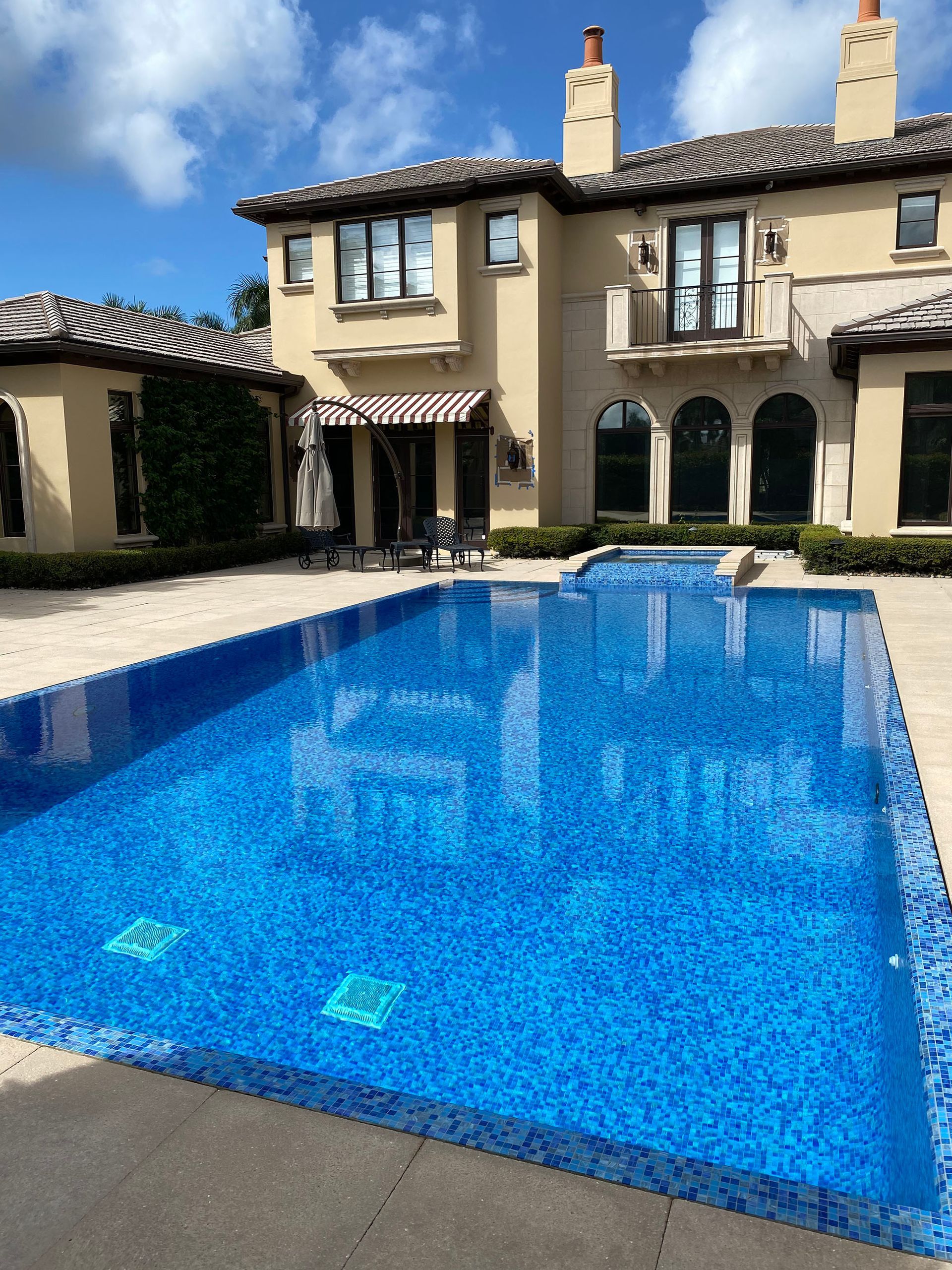A large house with a large swimming pool in front of it