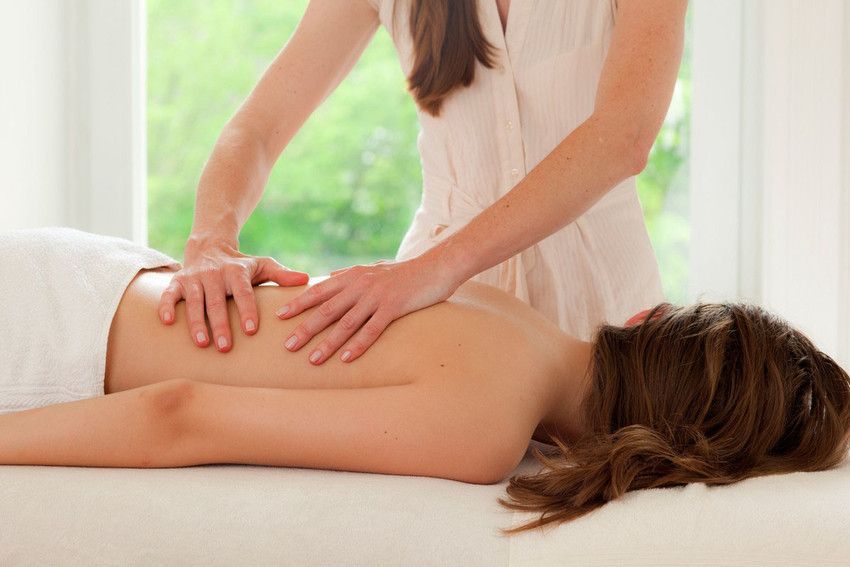 A woman is getting a massage on her back at a spa.