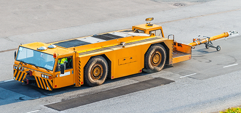 A large yellow truck is driving down a road