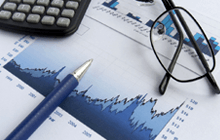 Close up of stock market chart, glasses, calculator and pen