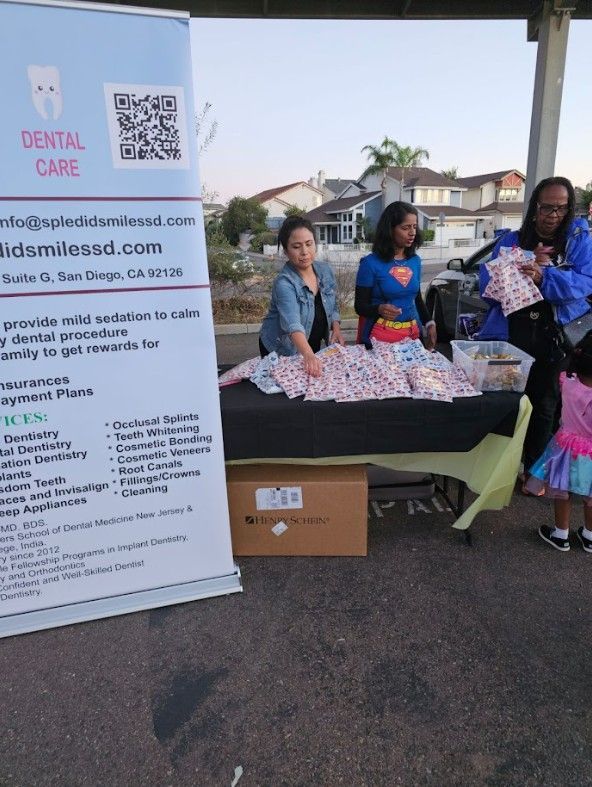 A group of people standing around a table with a sign that says dental care