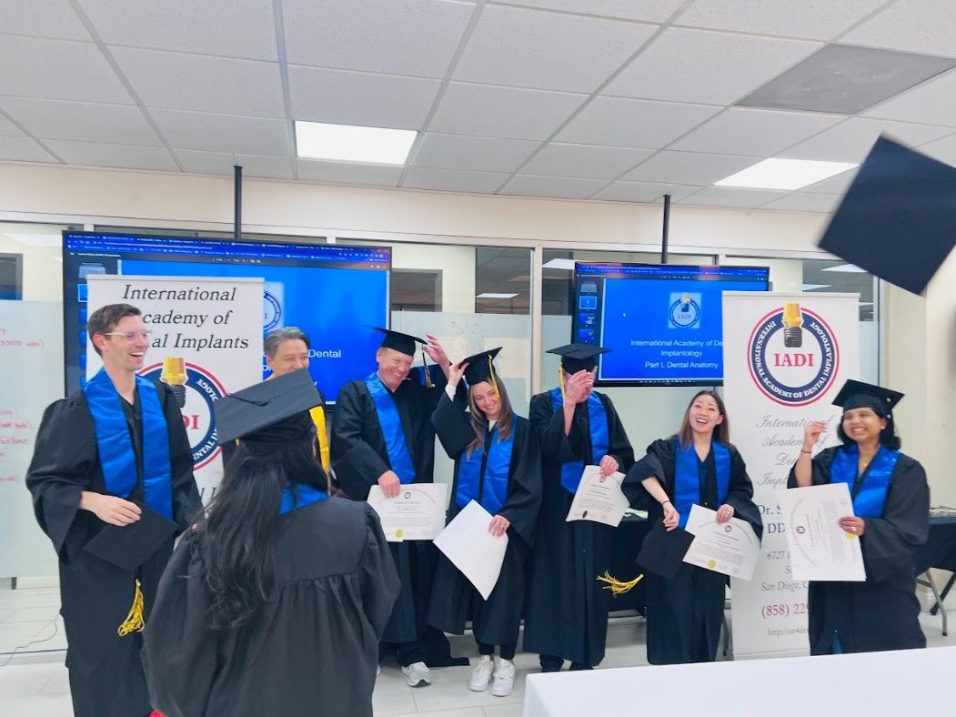 A group of graduates are standing in a room throwing their caps in the air.
