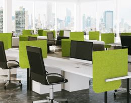 Bright office cubicles with green dividers and city view.
