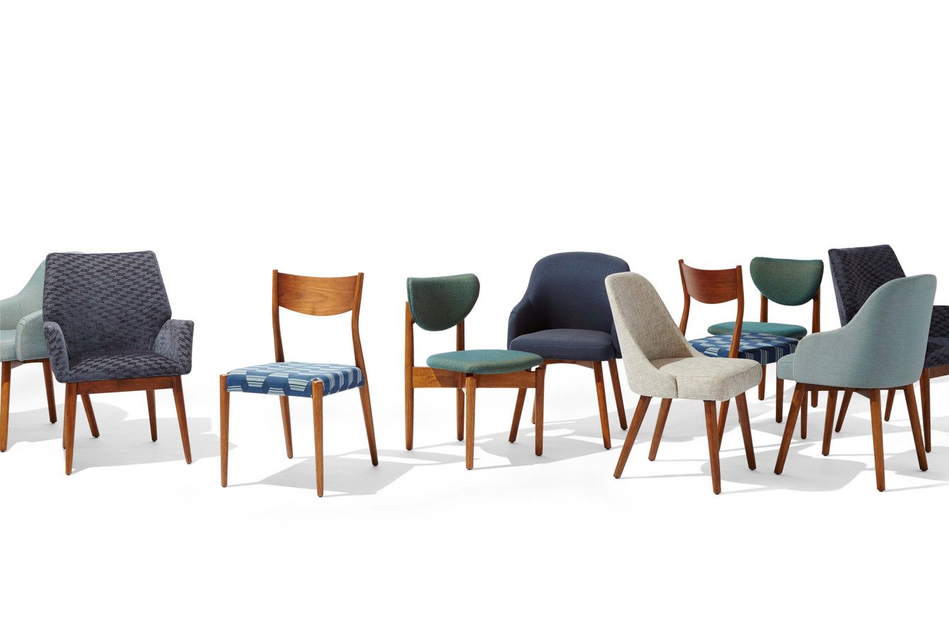 Assorted vintage dining chairs in various colors and designs on a white background.