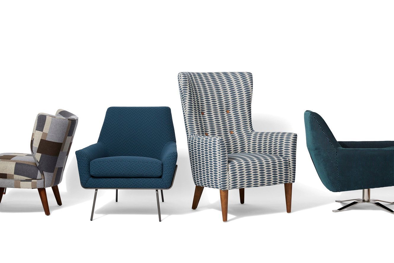 Four stylish armchairs with patterned and solid blue upholstery, against a white background.