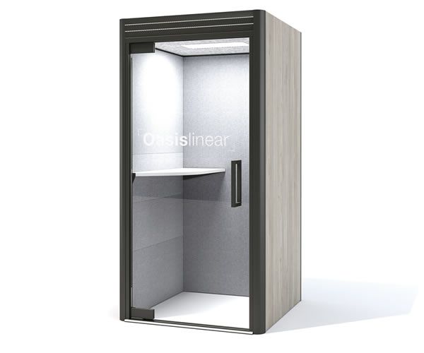 Office phone booth, gray and beige, with a shelf and door, lit from above, against white background.