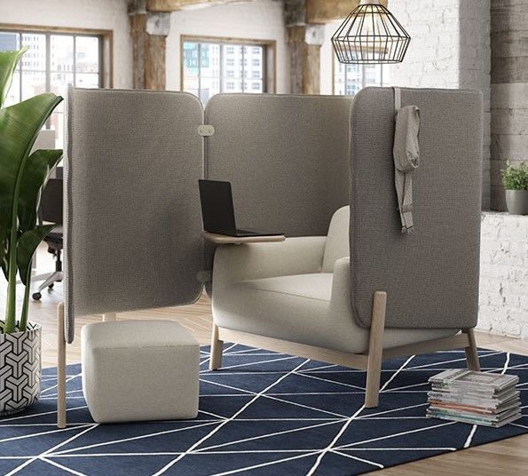 Gray office chair with high back panels and a side table, with a laptop, ottoman, and coat rack.