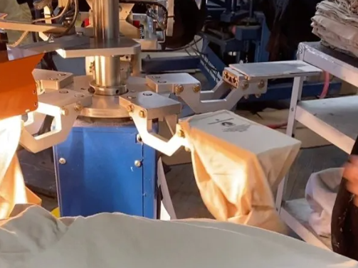 Automated t-shirt screen printing machine in operation; a shirt is being printed.