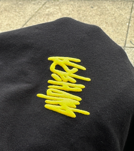 Black fabric with yellow embroidered stylized 