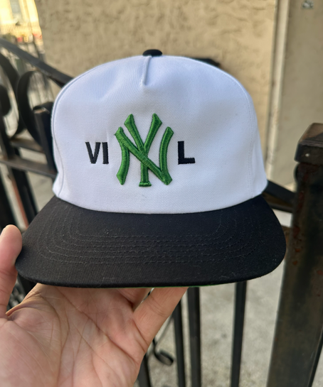 White and black baseball cap with a green 