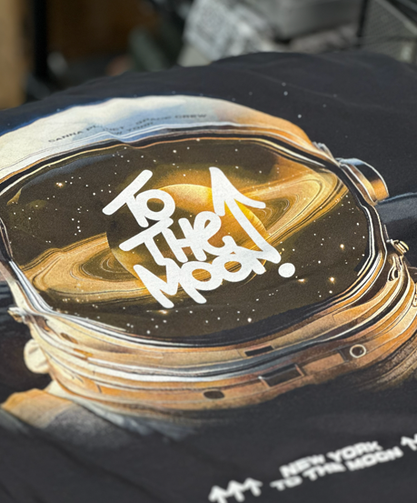 Close-up of a black t-shirt with a space theme.  