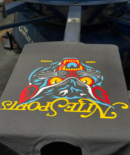 Gray t-shirt with a colorful screen-printed design. A tiger-like face above 