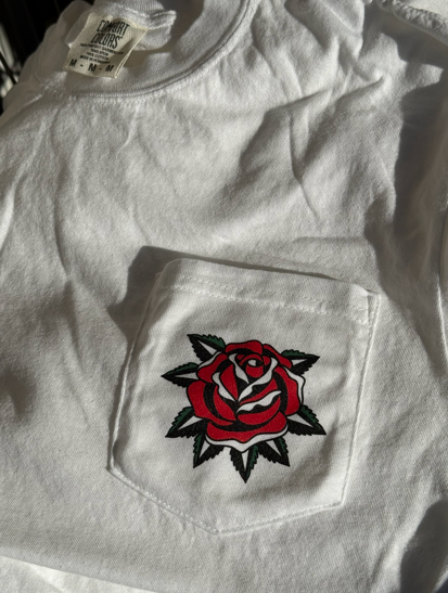 White t-shirt with embroidered red rose on a pocket.