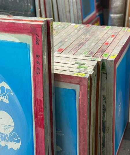 Stacked screen printing frames, red edges, blue mesh.