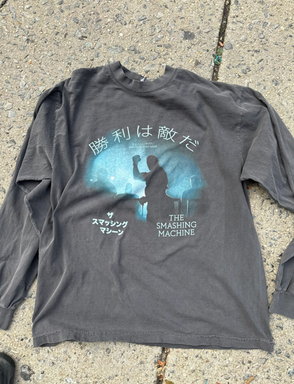 Gray long-sleeve shirt with Japanese text and silhouette of a person raising a fist, text reads 