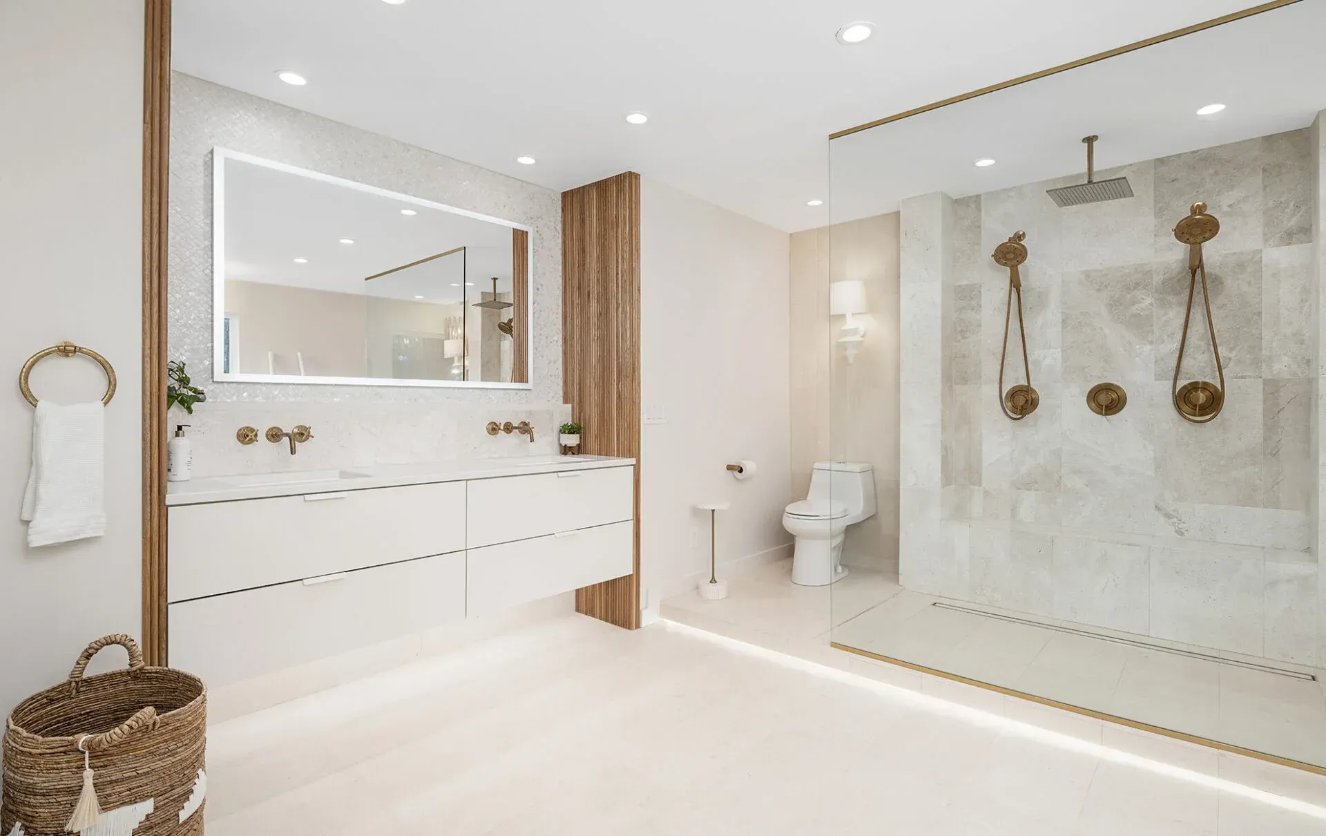 Modern white bathroom with a glass shower and gold accents.