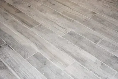 Gray, wood-look floor tiles arranged diagonally.