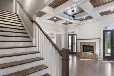 Staircase leading up to a living area with a fireplace and wood beam ceiling.