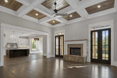 Spacious living room with hardwood floors, a fireplace, and a coffered ceiling with wood panels.