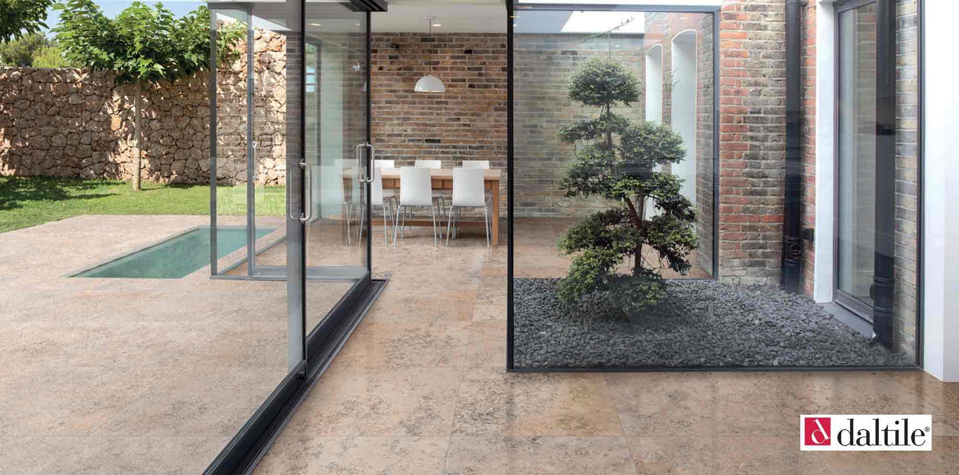 Modern home interior with glass walls, outdoor patio, zen garden, and dining area.