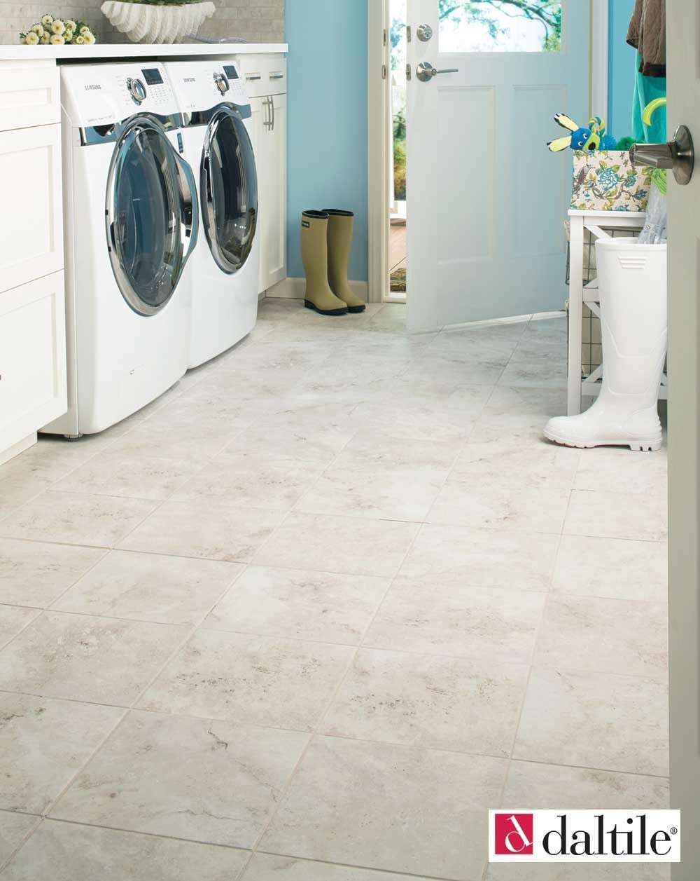 Laundry room with washing machine, light-colored flooring, and open door to the outside.