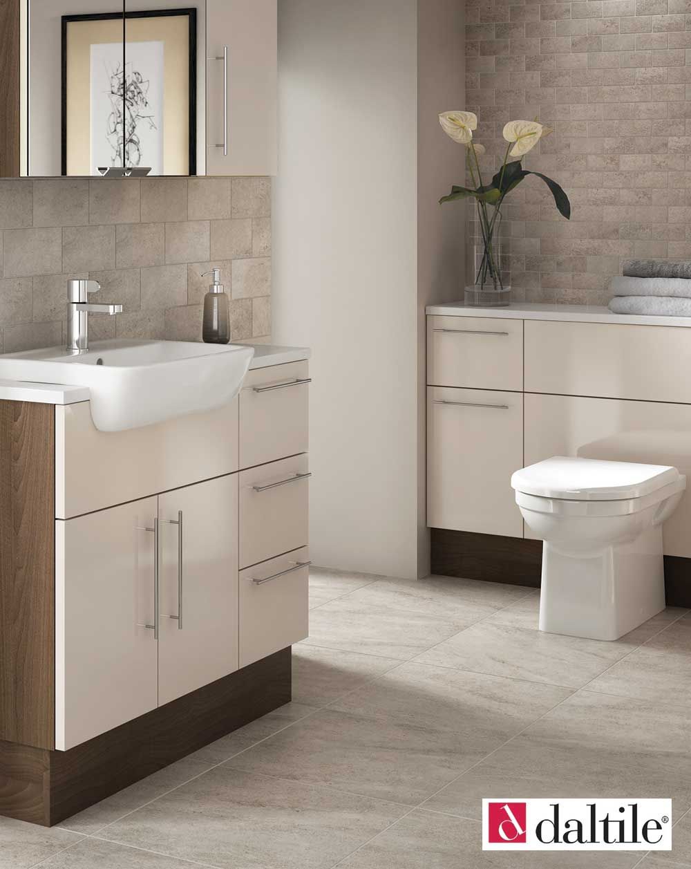 Bathroom with a white toilet, sink, and cabinetry. Beige walls and floor.