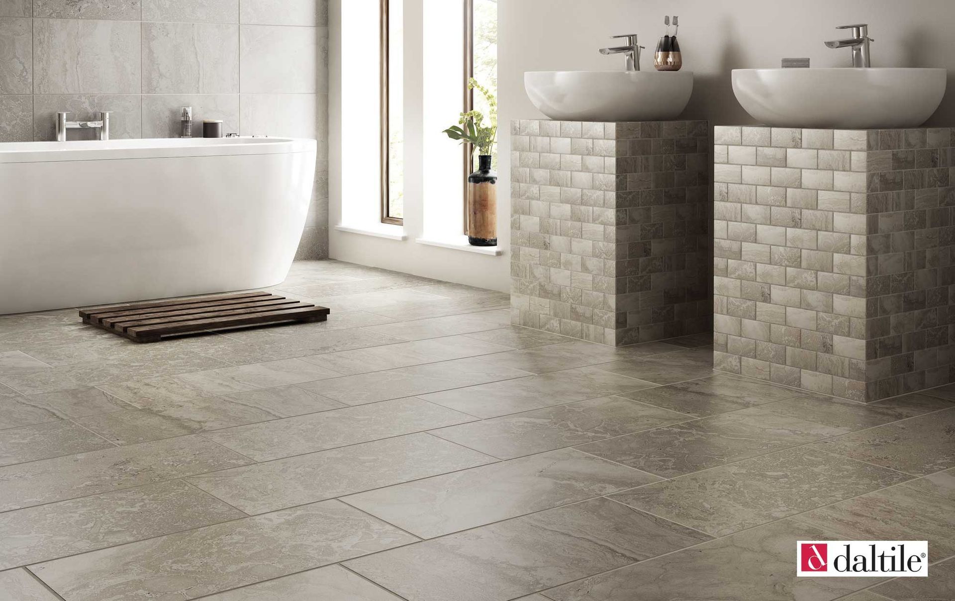 Bathroom with a white bathtub, two vessel sinks on brick columns, and large stone-look tiles.
