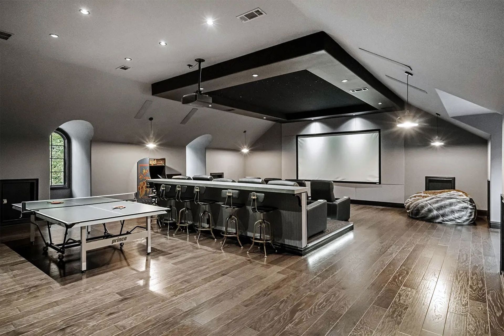 Home theater room with a bar, projector screen, and ping-pong table.