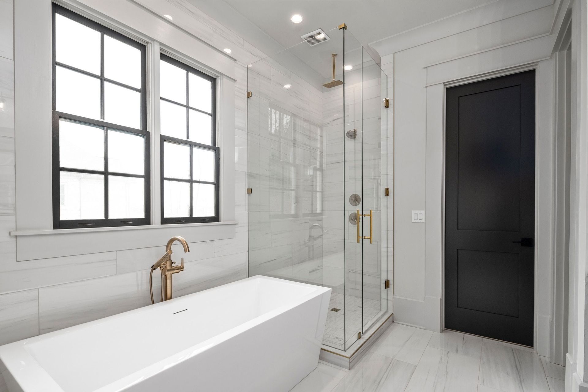 A modern bathroom with a white tub, shower, and accents.