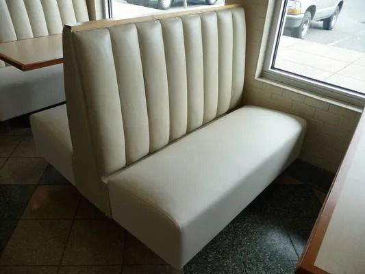 White vinyl booth seat by a window in a diner or café